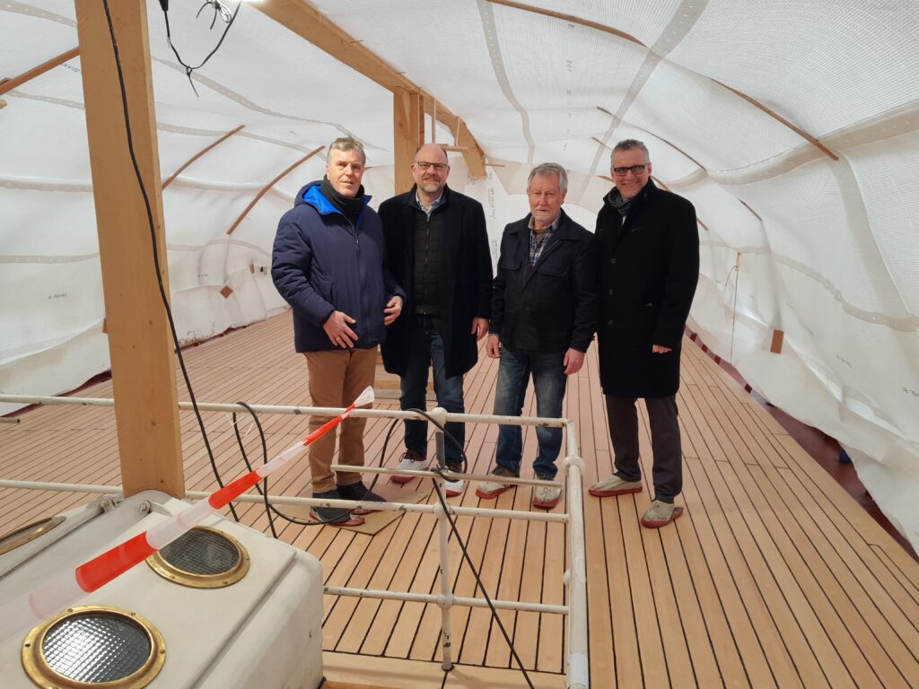 Das Oberdeck ist bereits neu beplankt: (v.r.) Stephan Janssen (Sparkasse LeerWittmund), Hans Appiß (Traditionsschiff Prinz Heinrich e.V.), Arne Butt (Niedersächsische Sparkassenstiftung) und Carsten Mohr (Sparkasse Leer/Wittmund) freuen sich über den Restaurierungsfortschritt, Foto: A. Butt