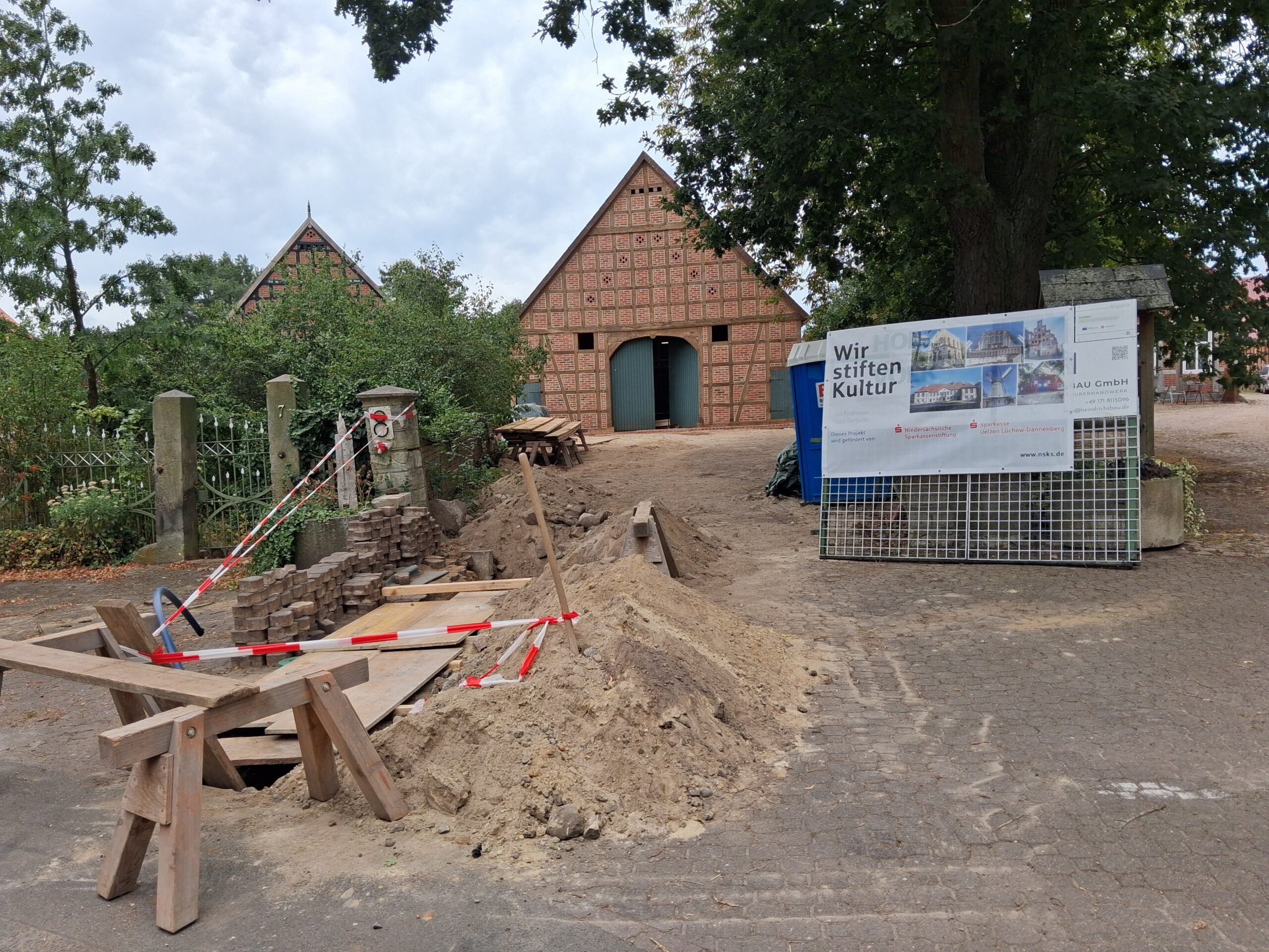 Blick vom zentralen Dorfplatz mit Arbeiten am Wasseranschluss (links), Foto: Arne Butt