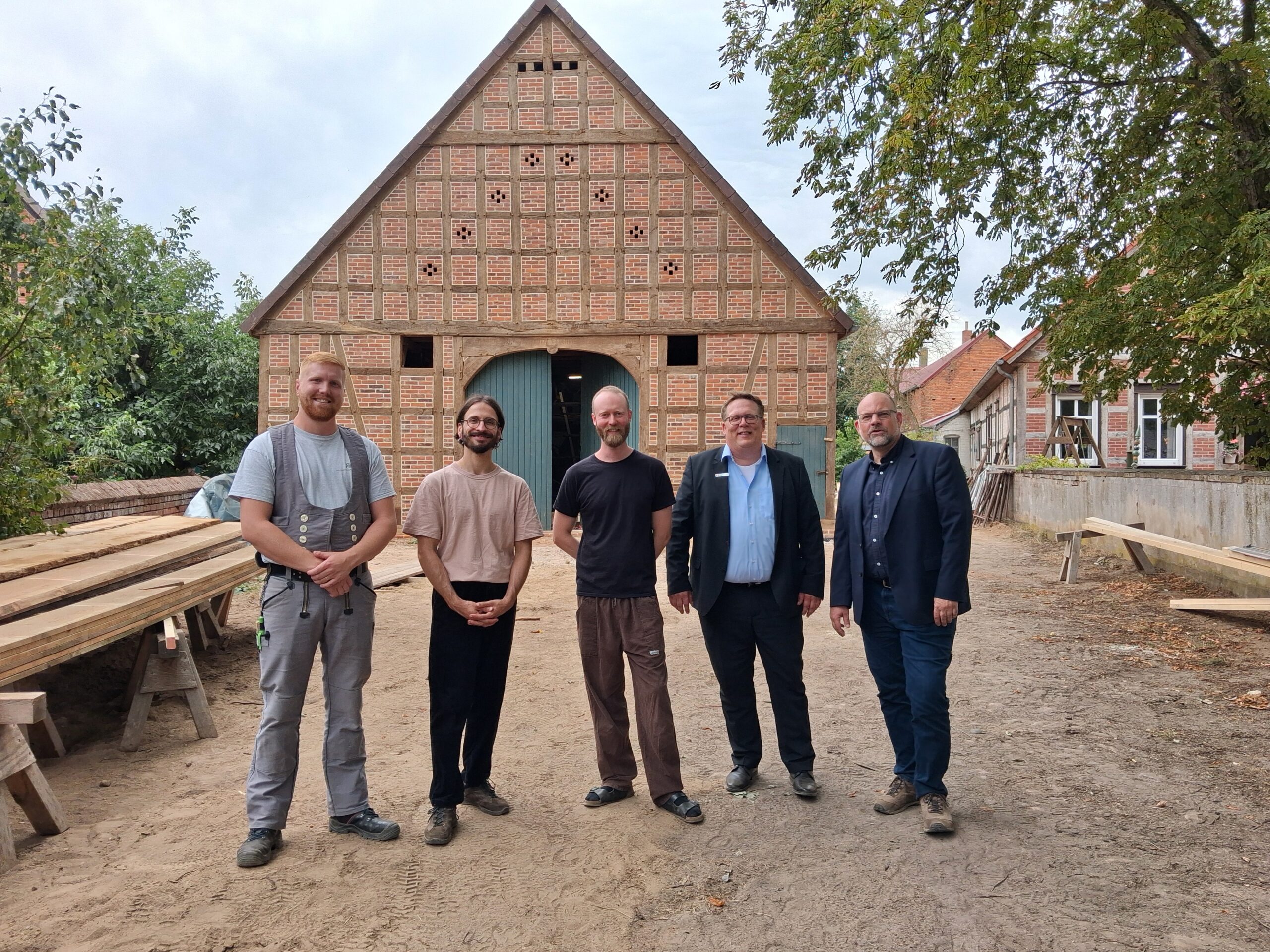 Präsentation der fertiggestellten Nordfassade am 28. August 2026 mit Ruben Heindrichs (HeindrichsBau Lüchow), Kay Fischer und Jonas Käckenmester (Projektverantwortliche/Architekten), Steffen Sowa (Sparkasse Uelzen Lüchow-Dannenberg), Arne Butt (Niedersächsische Sparkassenstiftung), Foto: Arne Butt